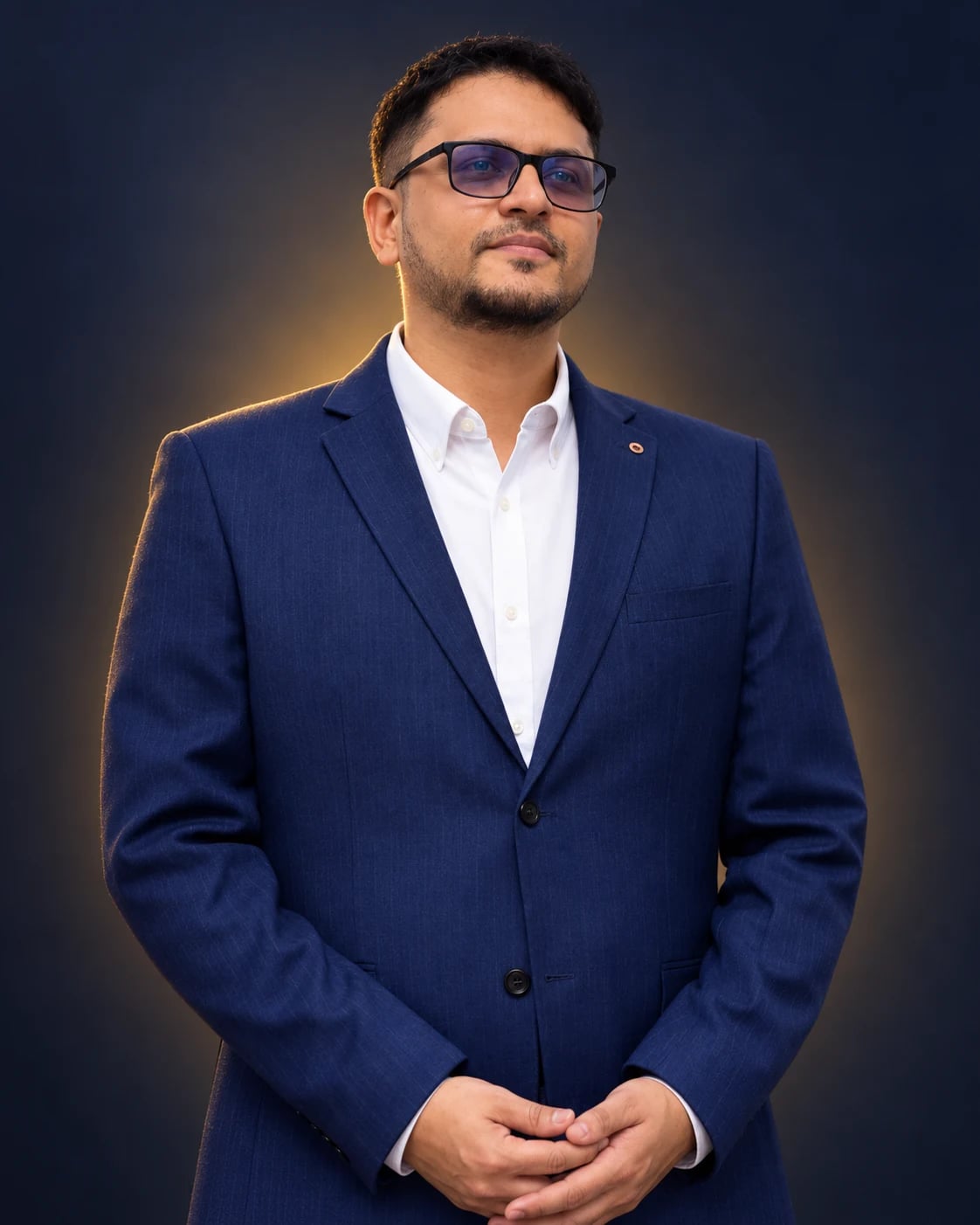 Mohamed Yacoob in a navy suit and glasses, photographed from the waist up
